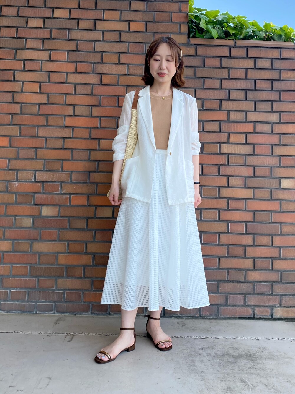 ホワイト系のテーラードジャケット、イエロー系のカーディガン/ボレロ、イエロー系のニット/セーターを着用したレディースの夏コーディネートの4枚目の写真