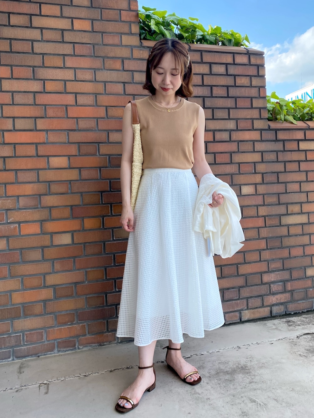 ホワイト系のテーラードジャケット、イエロー系のカーディガン/ボレロ、イエロー系のニット/セーターを着用したレディースの夏コーディネートの2枚目の写真