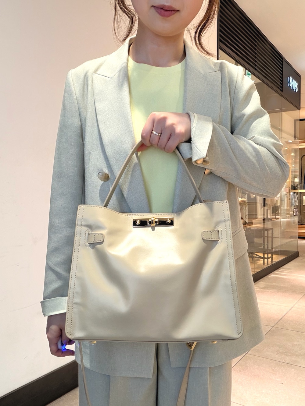 ベージュ系のその他パンツ、ベージュ系のテーラードジャケット、ベージュ系のトートバッグを着用したレディースの春コーディネートの7枚目の写真