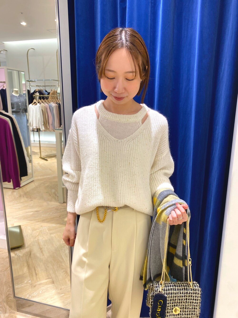 ホワイト系のニット/セーター、イエロー系のその他アウター、イエロー系のストール/ショールを着用したレディースの冬コーディネートの4枚目の写真