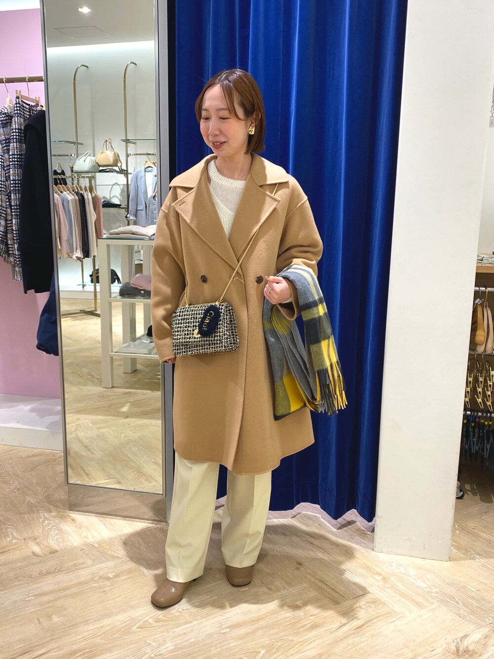 ホワイト系のニット/セーター、イエロー系のその他アウター、イエロー系のストール/ショールを着用したレディースの冬コーディネートの5枚目の写真