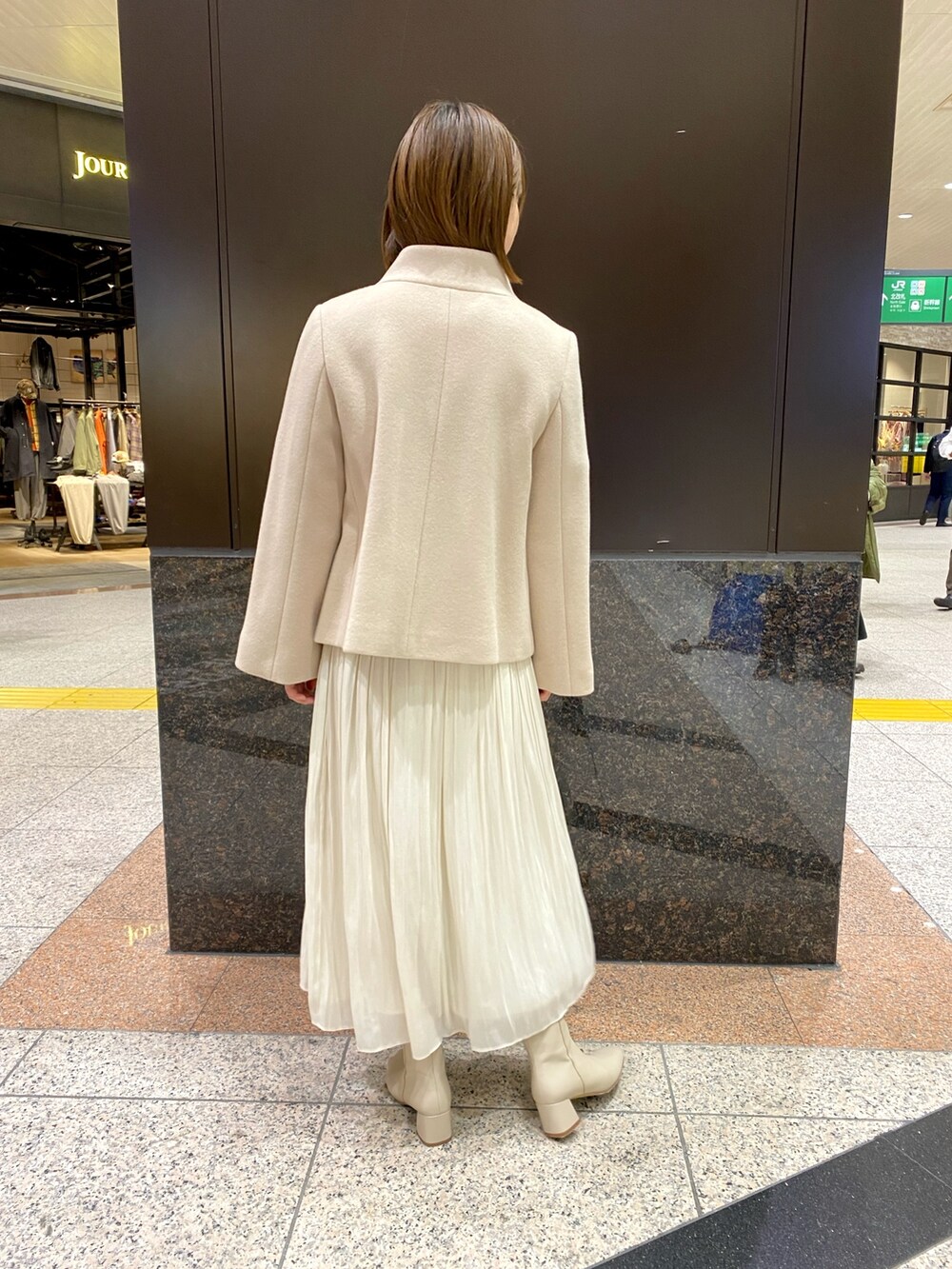 ホワイト系のスカート、ベージュ系のニット/セーター、ベージュ系のその他アウターを着用したレディースの冬コーディネートの3枚目の写真