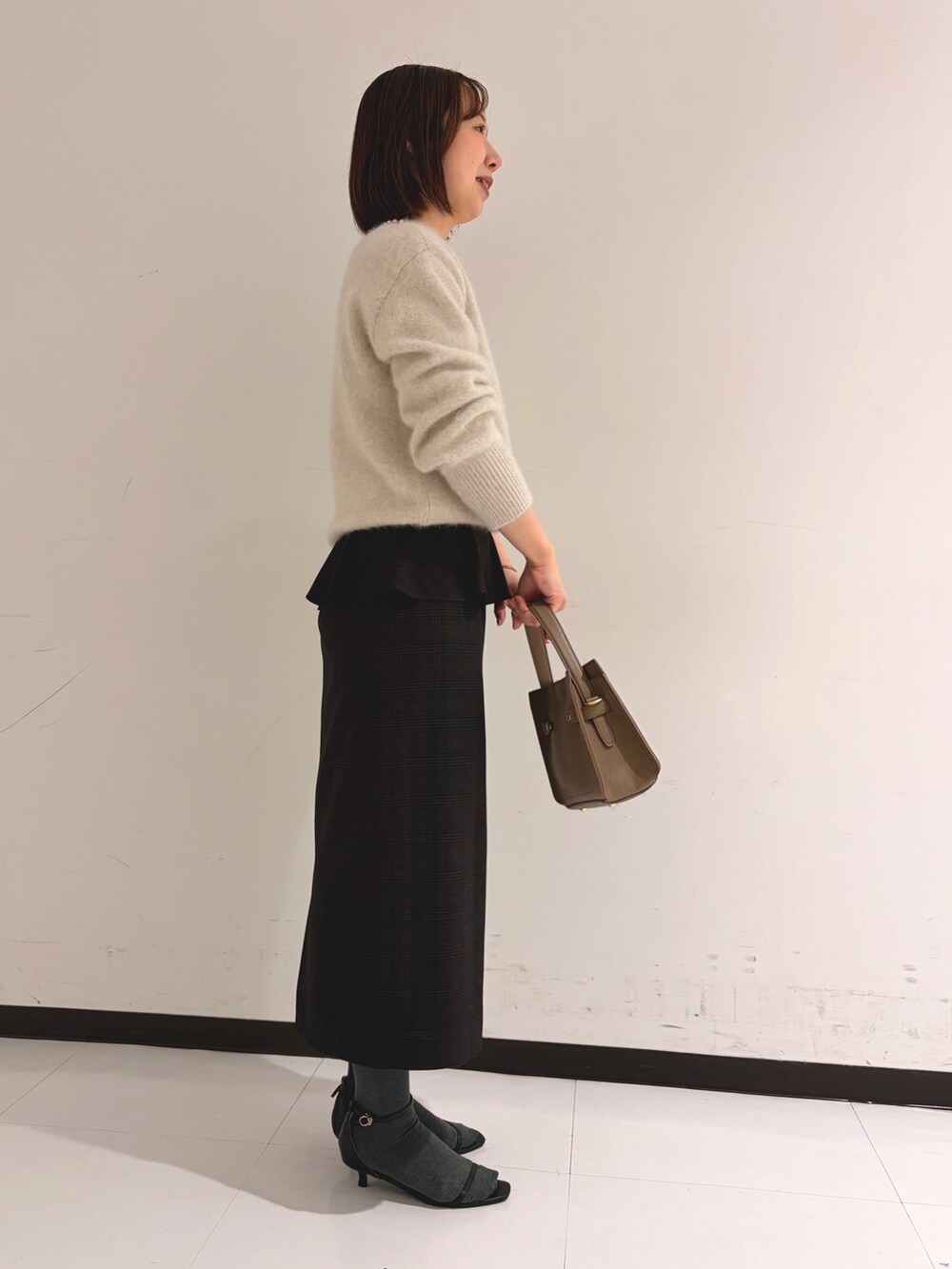 ベージュ系のニット/セーター、ベージュ系のスカートを着用したレディースの秋コーディネートの2枚目の写真