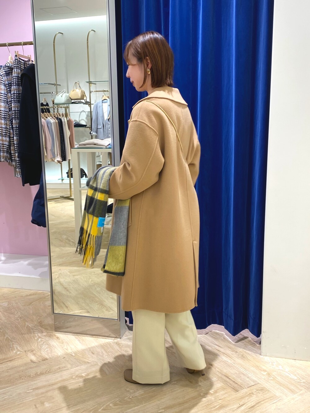 ホワイト系のニット/セーター、イエロー系のその他アウター、イエロー系のストール/ショールを着用したレディースの冬コーディネートの8枚目の写真