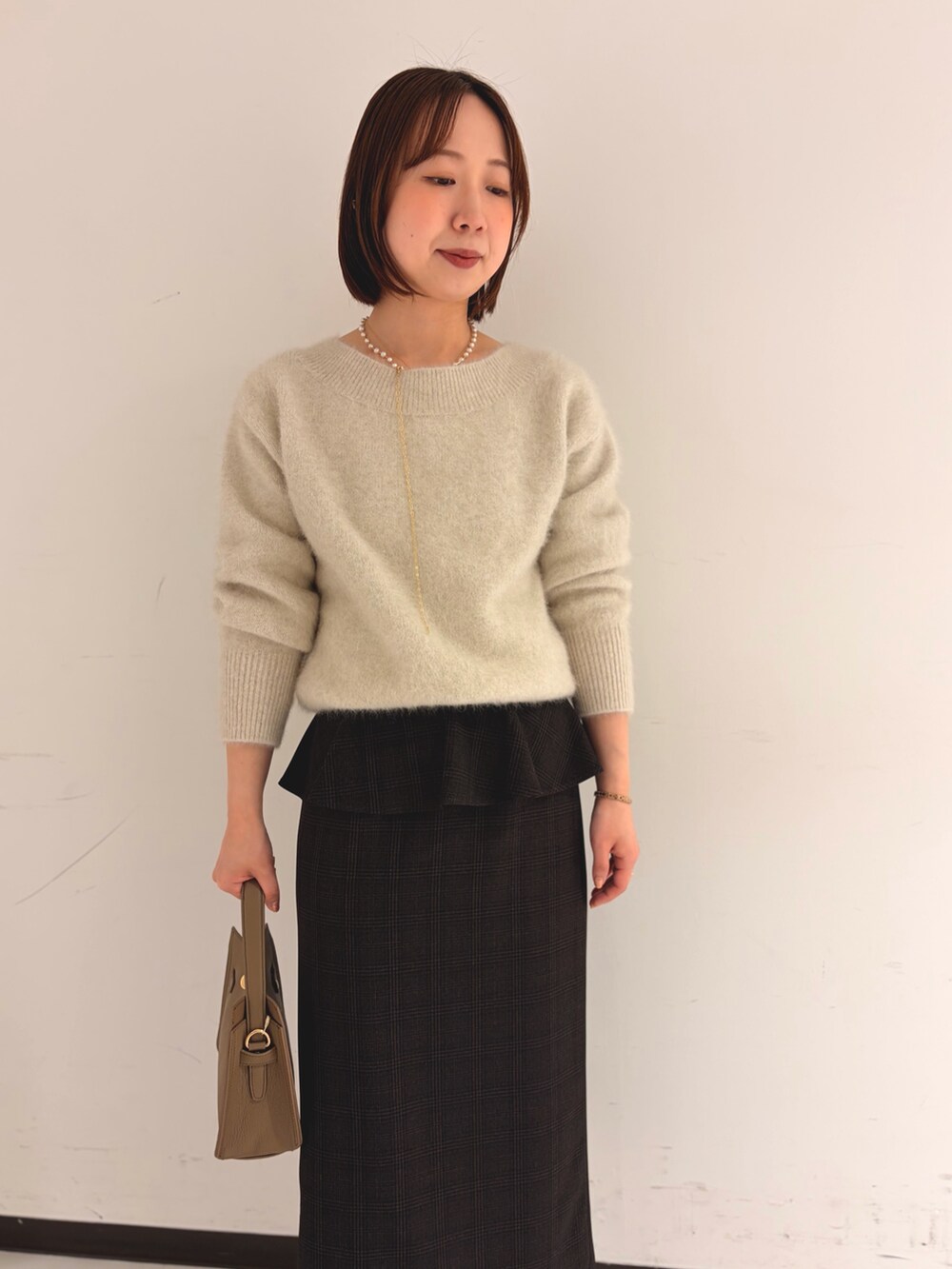 ベージュ系のニット/セーター、ベージュ系のスカートを着用したレディースの秋コーディネートの6枚目の写真