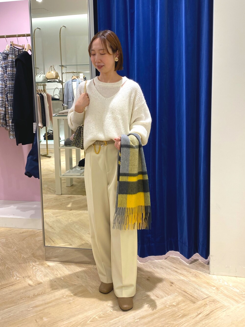 ホワイト系のニット/セーター、イエロー系のその他アウター、イエロー系のストール/ショールを着用したレディースの冬コーディネートの2枚目の写真