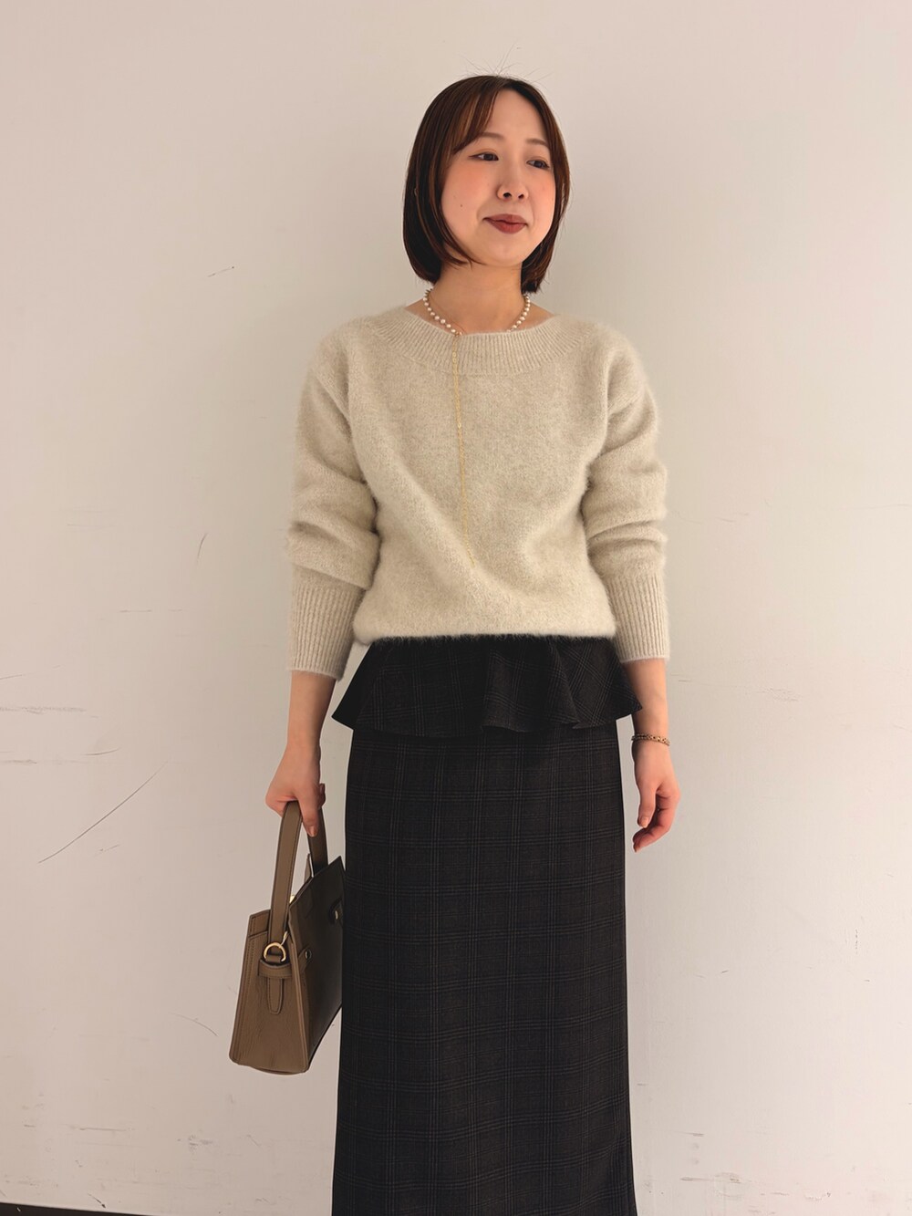 ベージュ系のニット/セーター、ベージュ系のスカートを着用したレディースの秋コーディネートの5枚目の写真