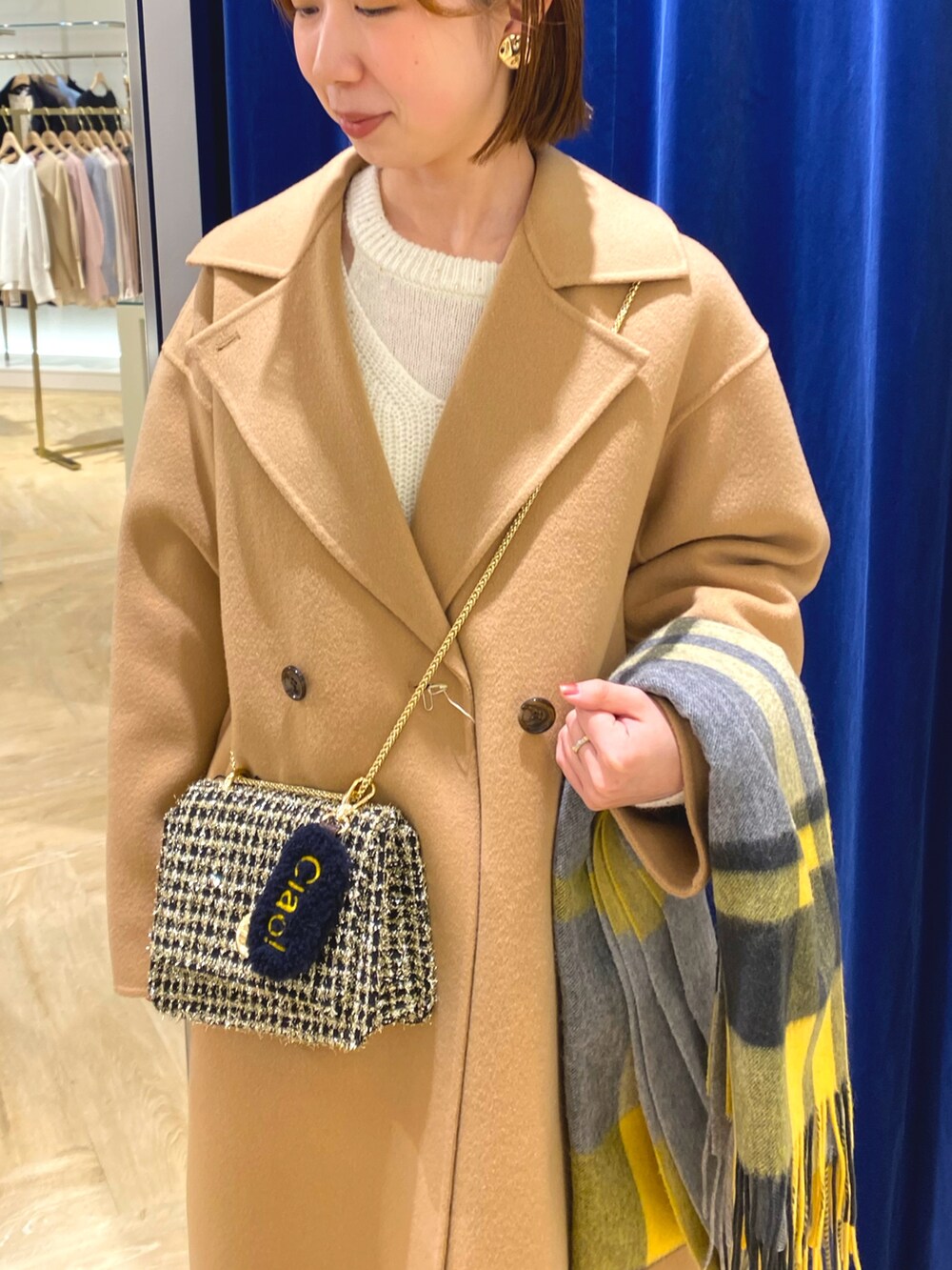 ホワイト系のニット/セーター、イエロー系のその他アウター、イエロー系のストール/ショールを着用したレディースの冬コーディネートの7枚目の写真