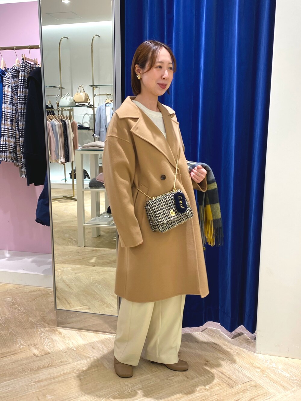 ホワイト系のニット/セーター、イエロー系のその他アウター、イエロー系のストール/ショールを着用したレディースの冬コーディネートの6枚目の写真