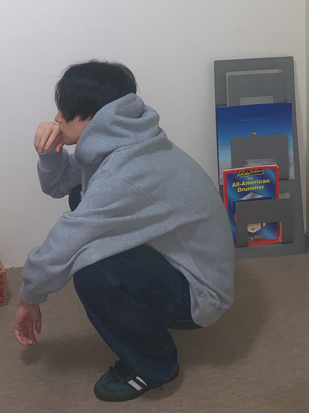 ブラック系のスニーカー、ブルー系のデニムパンツ、グレー系のパーカーを着用したメンズの秋コーディネートの2枚目の写真