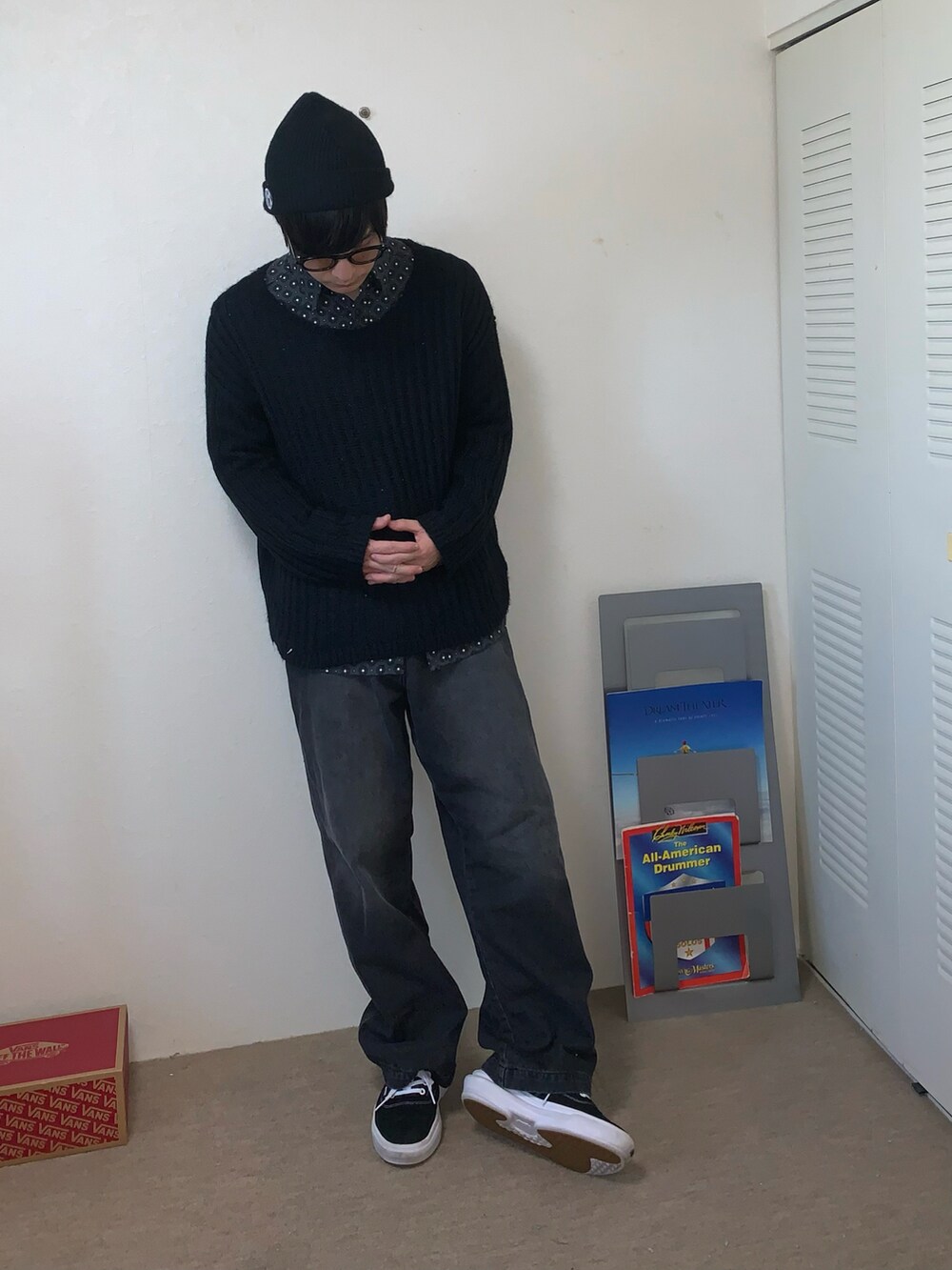 ブラック系のデニムパンツ、ブラック系のニット/セーター、ブラック系のスニーカーを着用したメンズの秋コーディネートの2枚目の写真