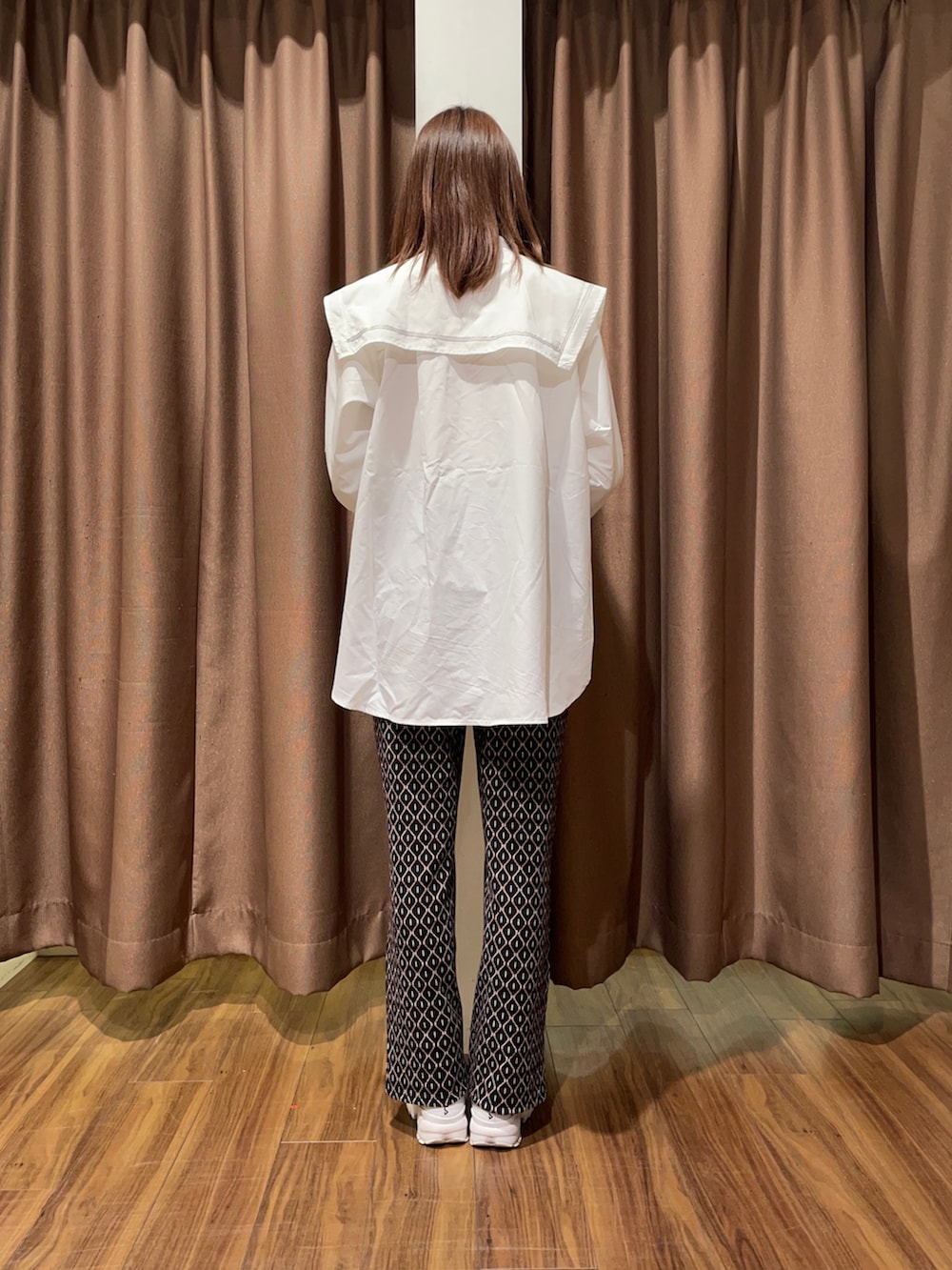 ホワイト系のスニーカー、ブラック系のその他パンツ、ホワイト系のシャツ/ブラウスを着用したレディースの秋コーディネートの3枚目の写真