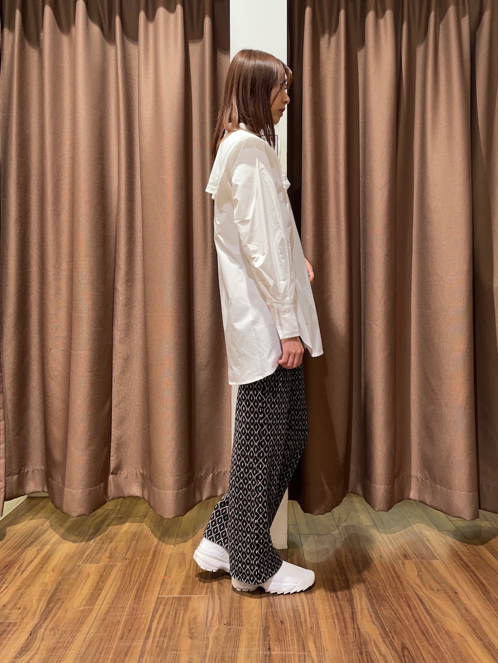 ホワイト系のスニーカー、ブラック系のその他パンツ、ホワイト系のシャツ/ブラウスを着用したレディースの秋コーディネートの4枚目の写真