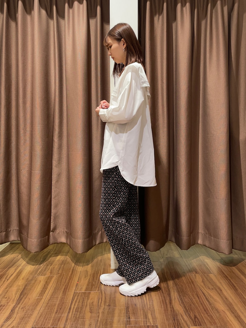 ホワイト系のスニーカー、ブラック系のその他パンツ、ホワイト系のシャツ/ブラウスを着用したレディースの秋コーディネートの2枚目の写真