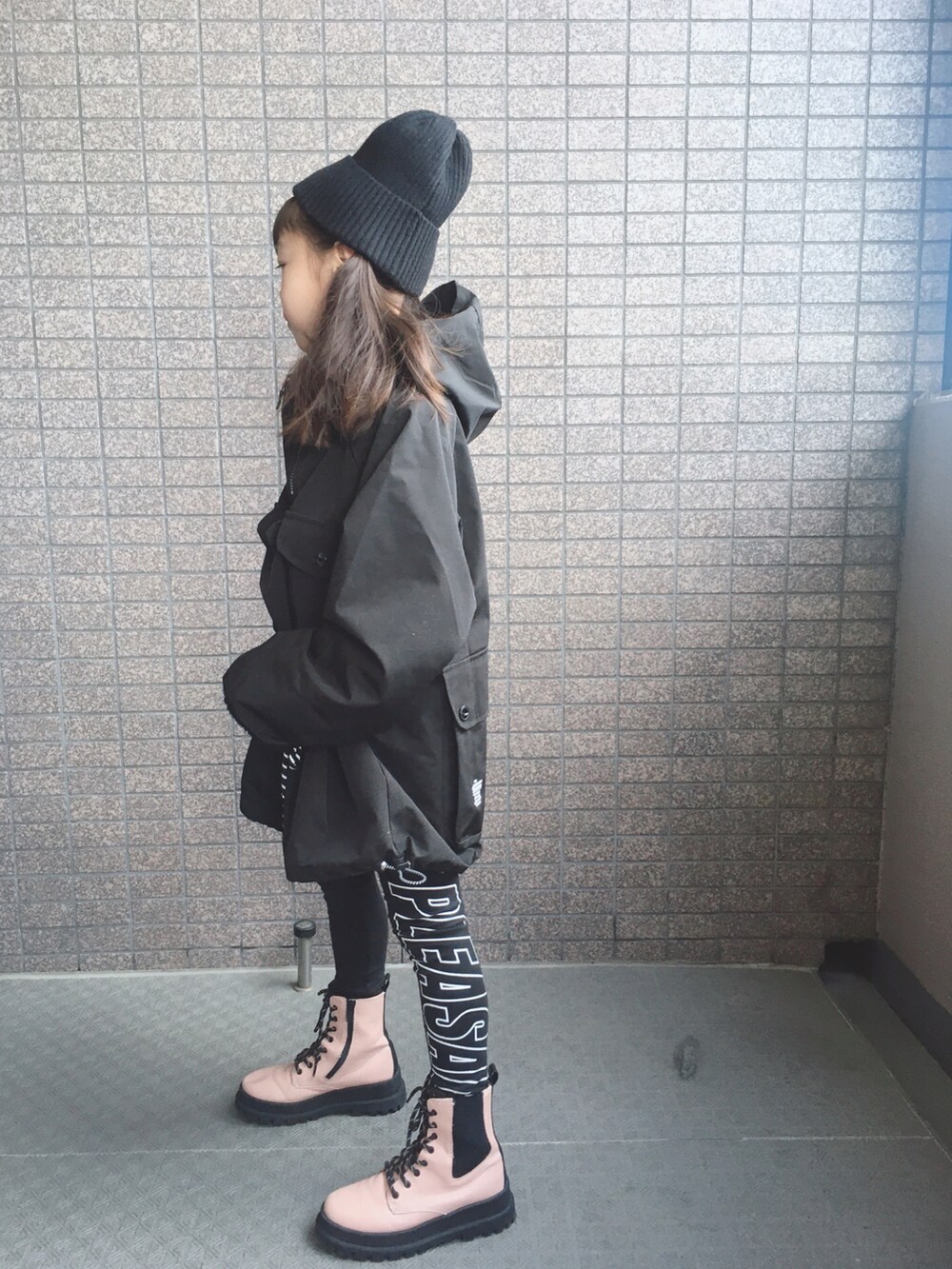 ブラック系のジャケット/アウター、ピンク系のブーツ、ブラック系のニットキャップ/ビーニーを着用したキッズの冬コーディネートの3枚目の写真