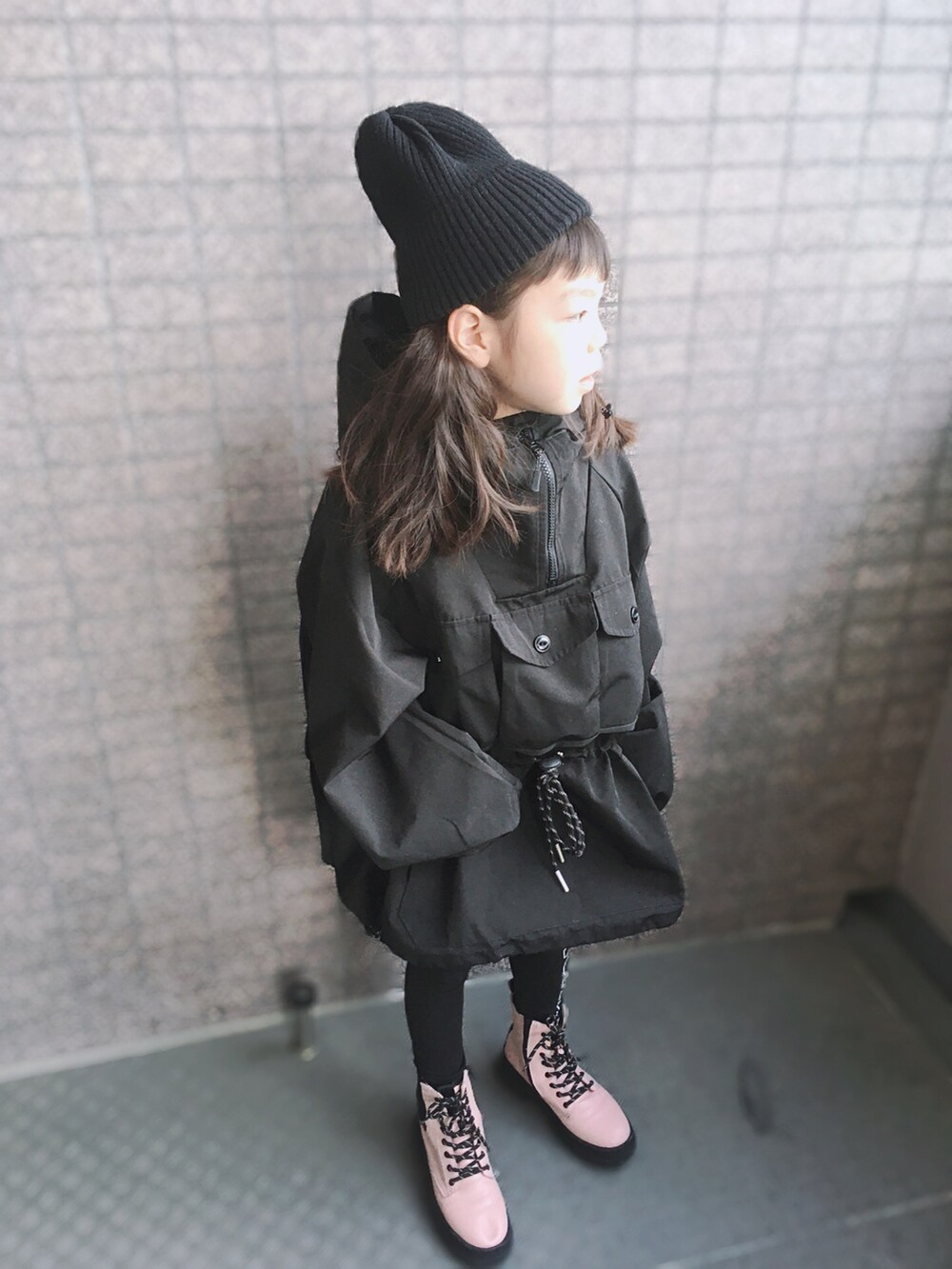ブラック系のジャケット/アウター、ピンク系のブーツ、ブラック系のニットキャップ/ビーニーを着用したキッズの冬コーディネートの2枚目の写真