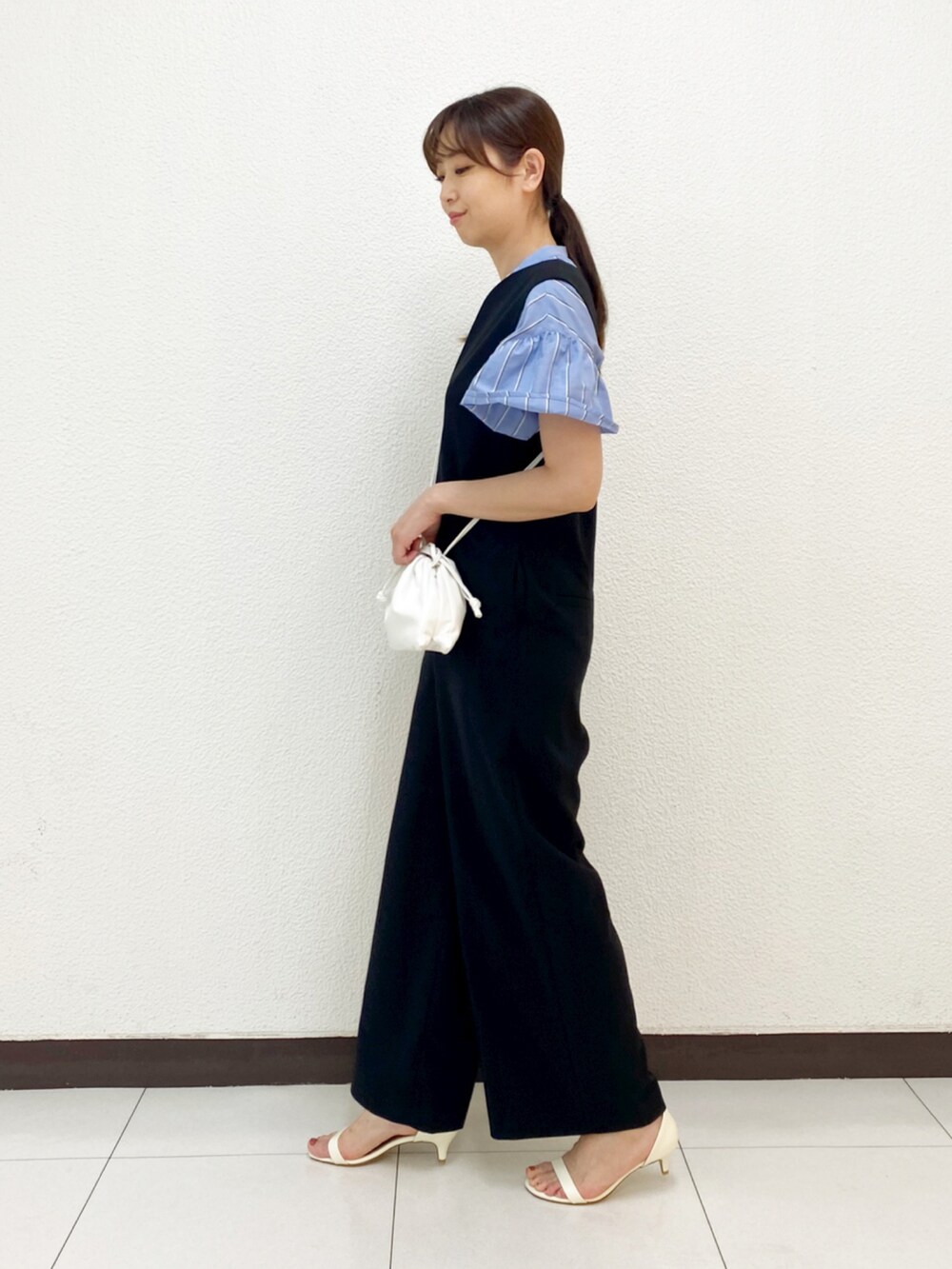 ブラック系のサロペット/オーバーオール、ホワイト系のサンダル、ブルー系のシャツ/ブラウスを着用したレディースの春コーディネートの3枚目の写真