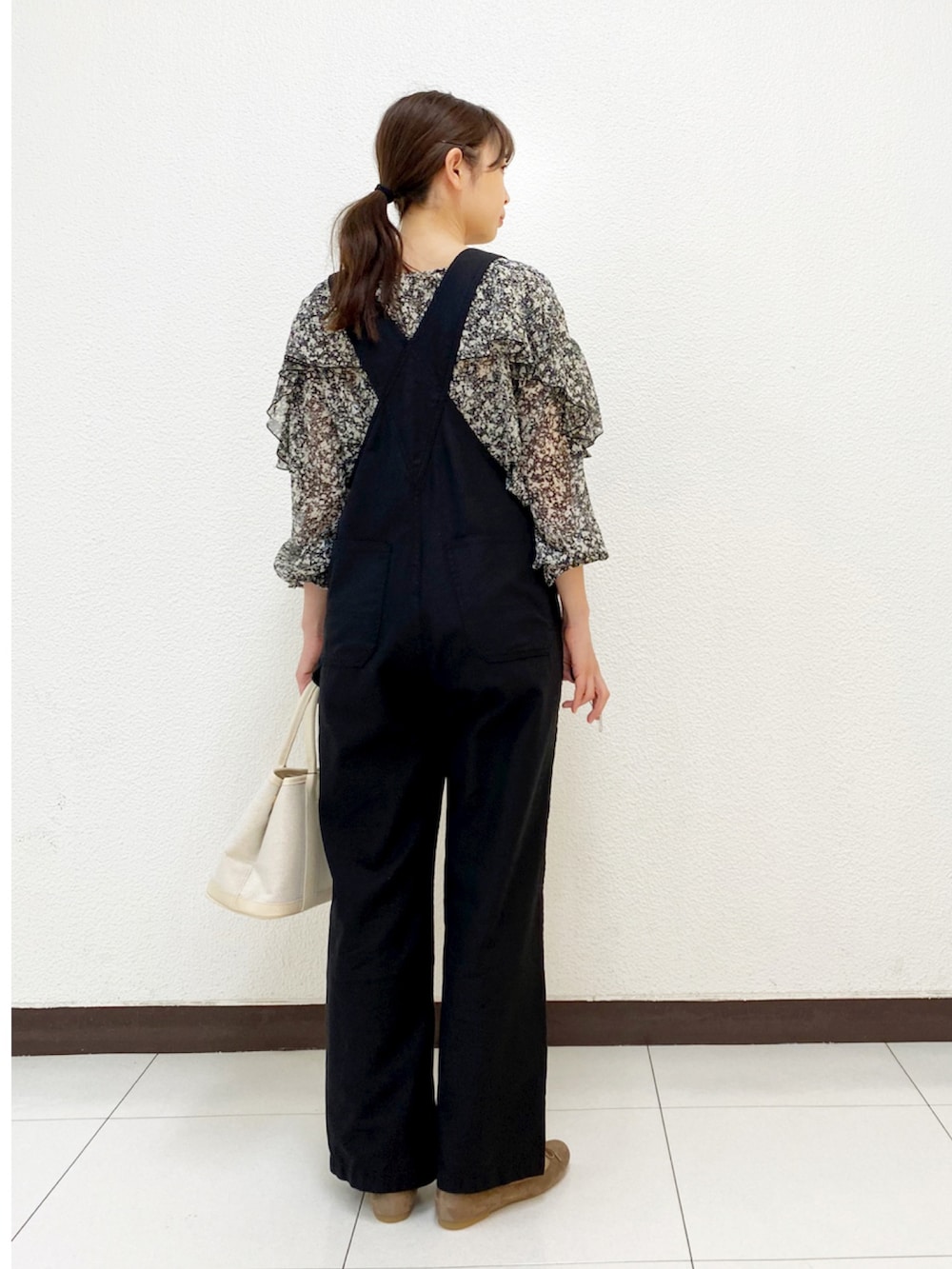 ベージュ系のトートバッグ、グリーン系のブルゾン、ブラック系のサロペット/オーバーオールを着用したレディースの春コーディネートの5枚目の写真