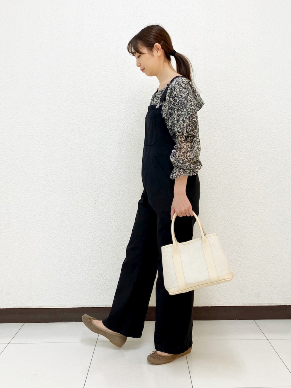 ベージュ系のトートバッグ、グリーン系のブルゾン、ブラック系のサロペット/オーバーオールを着用したレディースの春コーディネートの4枚目の写真