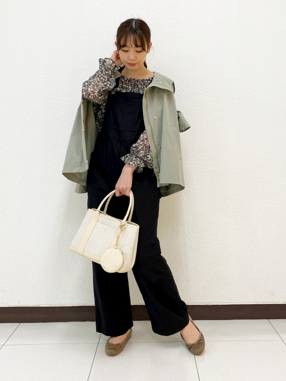 ベージュ系のトートバッグ、グリーン系のブルゾン、ブラック系のサロペット/オーバーオールを着用したレディースの春コーディネートの2枚目の写真