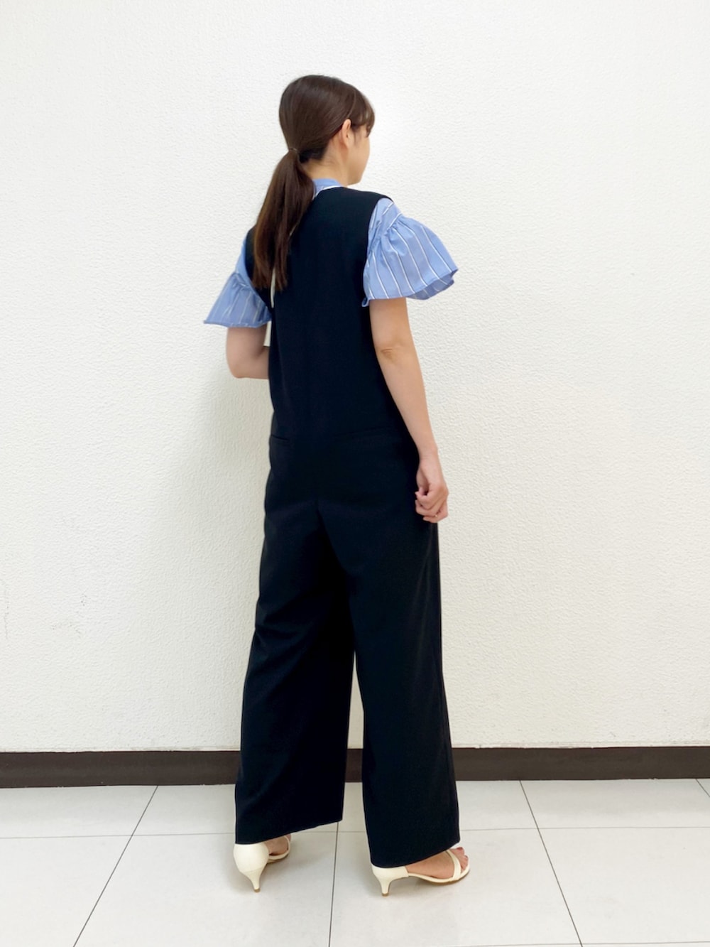 ブラック系のサロペット/オーバーオール、ホワイト系のサンダル、ブルー系のシャツ/ブラウスを着用したレディースの春コーディネートの4枚目の写真