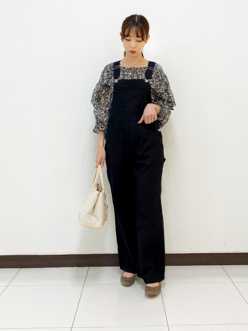 ベージュ系のトートバッグ、グリーン系のブルゾン、ブラック系のサロペット/オーバーオールを着用したレディースの春コーディネートの3枚目の写真