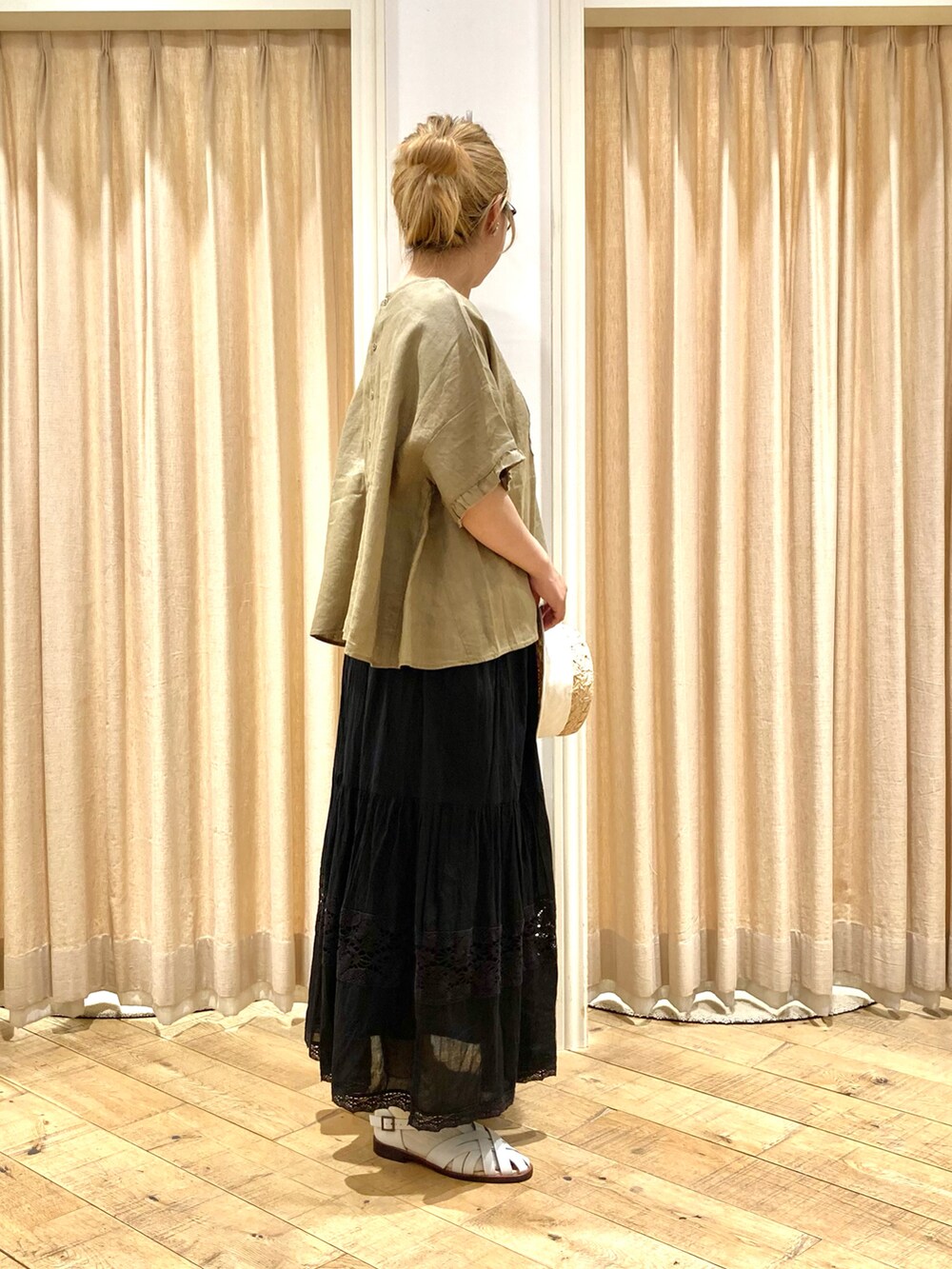 イエロー系のシャツ/ブラウス、ブラック系のスカート、ホワイト系のサンダルを着用したレディースの夏コーディネートの5枚目の写真
