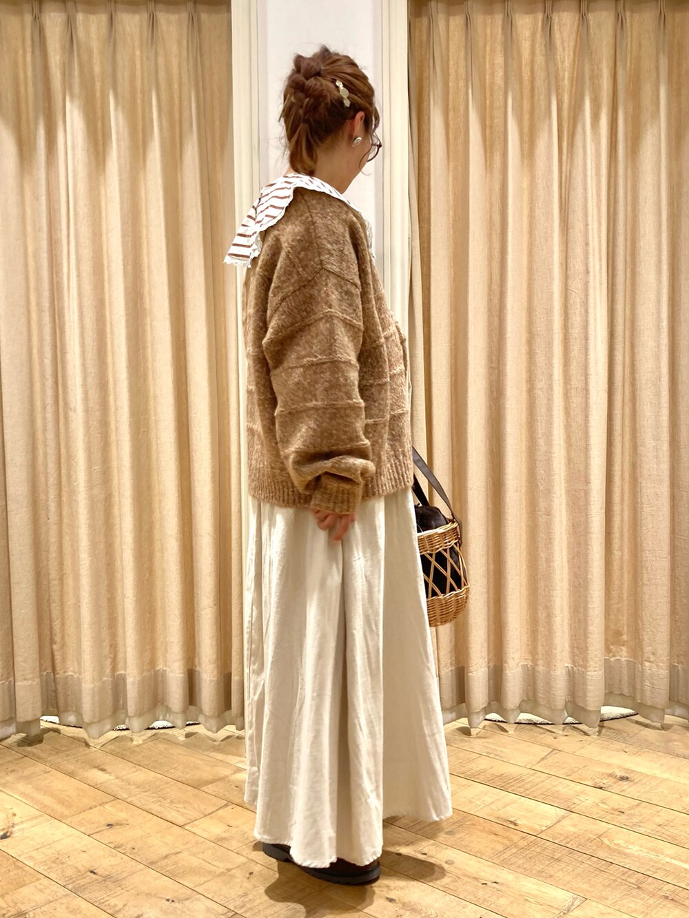 オレンジ系のカーディガン/ボレロ、ベージュ系のスカート、ベージュ系のTシャツ/カットソーを着用したレディースの秋コーディネートの4枚目の写真