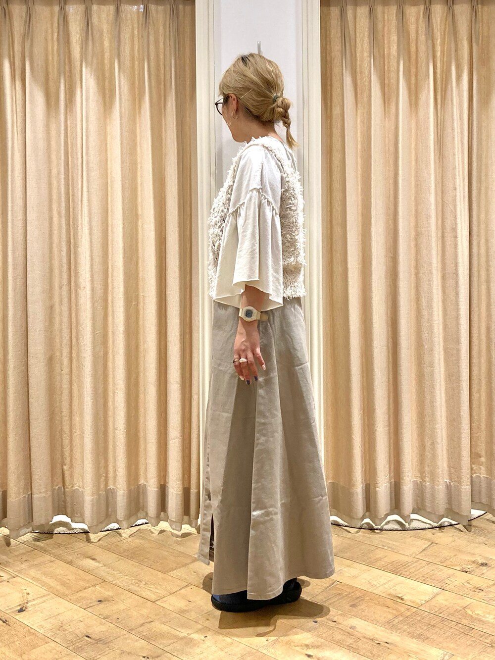 ホワイト系のTシャツ/カットソー、ホワイト系のベスト、ベージュ系のスカートを着用したレディースの秋コーディネートの2枚目の写真