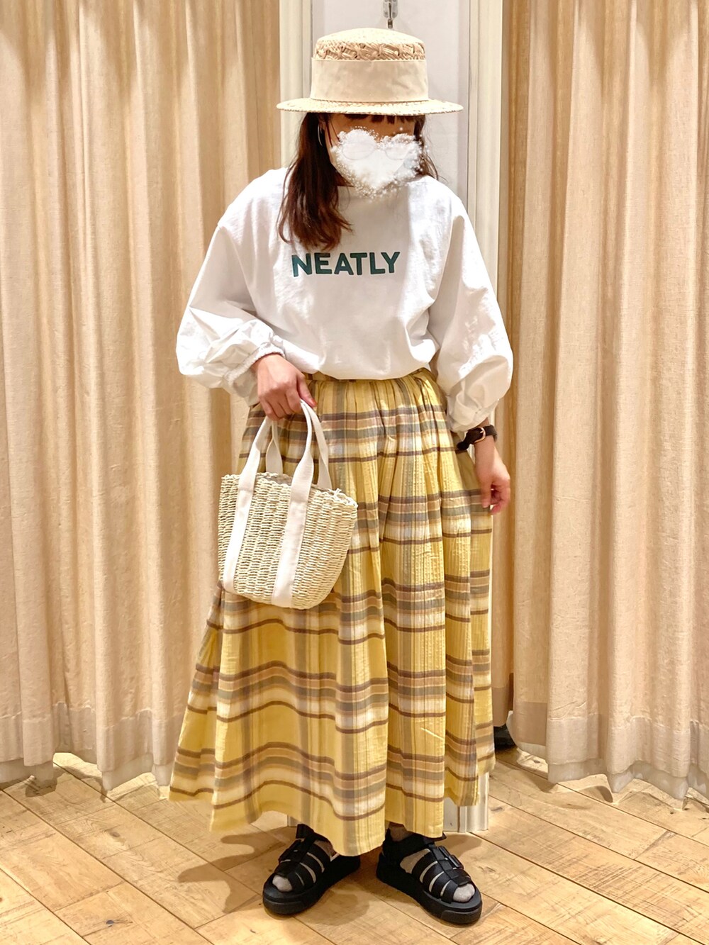 ホワイト系のTシャツ/カットソー、イエロー系のスカート、ホワイト系のハンドバッグを着用したレディースの春コーディネートの2枚目の写真