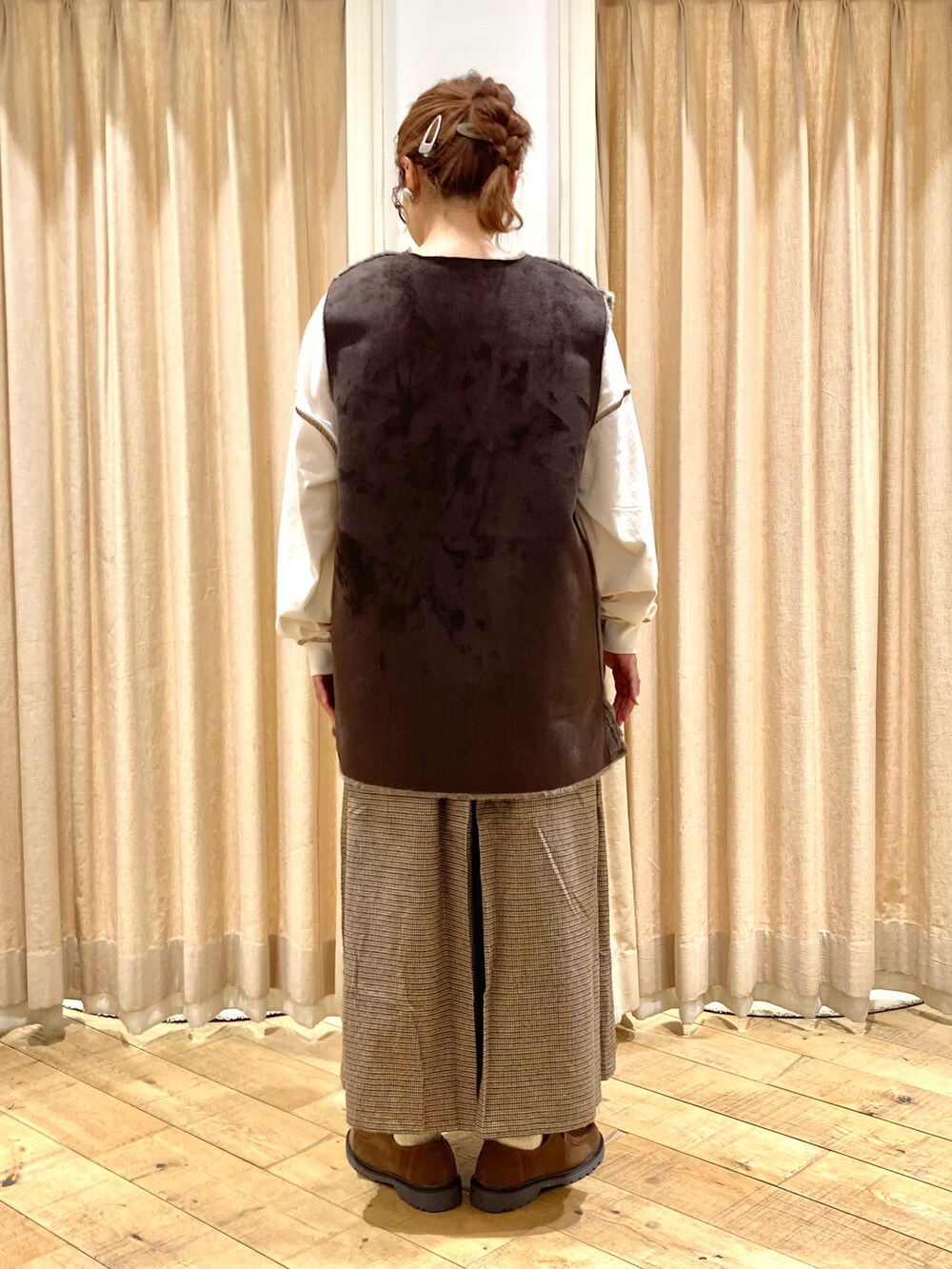 ホワイト系のTシャツ/カットソー、グレー系のベスト、ブラウン系のその他パンツを着用したレディースの秋コーディネートの4枚目の写真