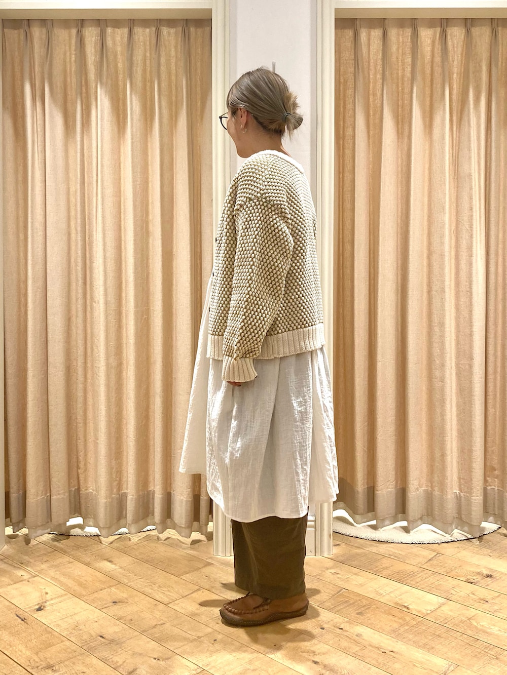 ホワイト系のチュニック、イエロー系のカーディガン/ボレロ、グリーン系のその他パンツを着用したレディースの冬コーディネートの3枚目の写真