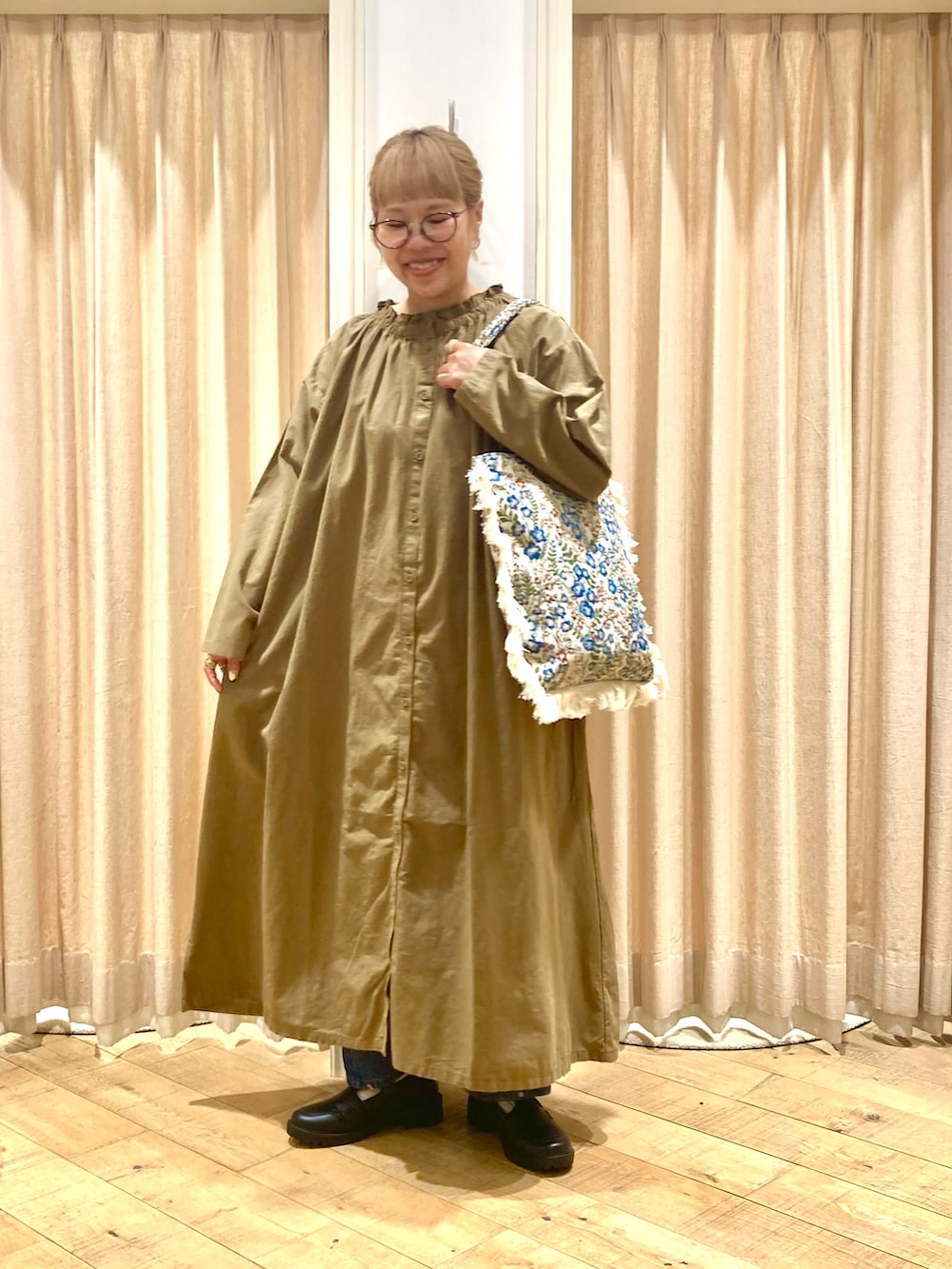 グリーン系のワンピース、ブルー系のその他パンツ、ブルー系のハンドバッグを着用したレディースの秋コーディネートの2枚目の写真