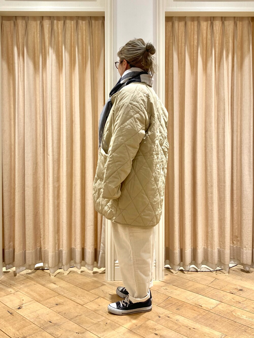 ベージュ系のその他アウター、グリーン系のニット/セーター、ホワイト系のその他パンツを着用したレディースの冬コーディネートの4枚目の写真