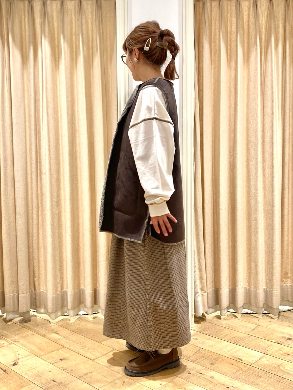 ホワイト系のTシャツ/カットソー、グレー系のベスト、ブラウン系のその他パンツを着用したレディースの秋コーディネートの3枚目の写真