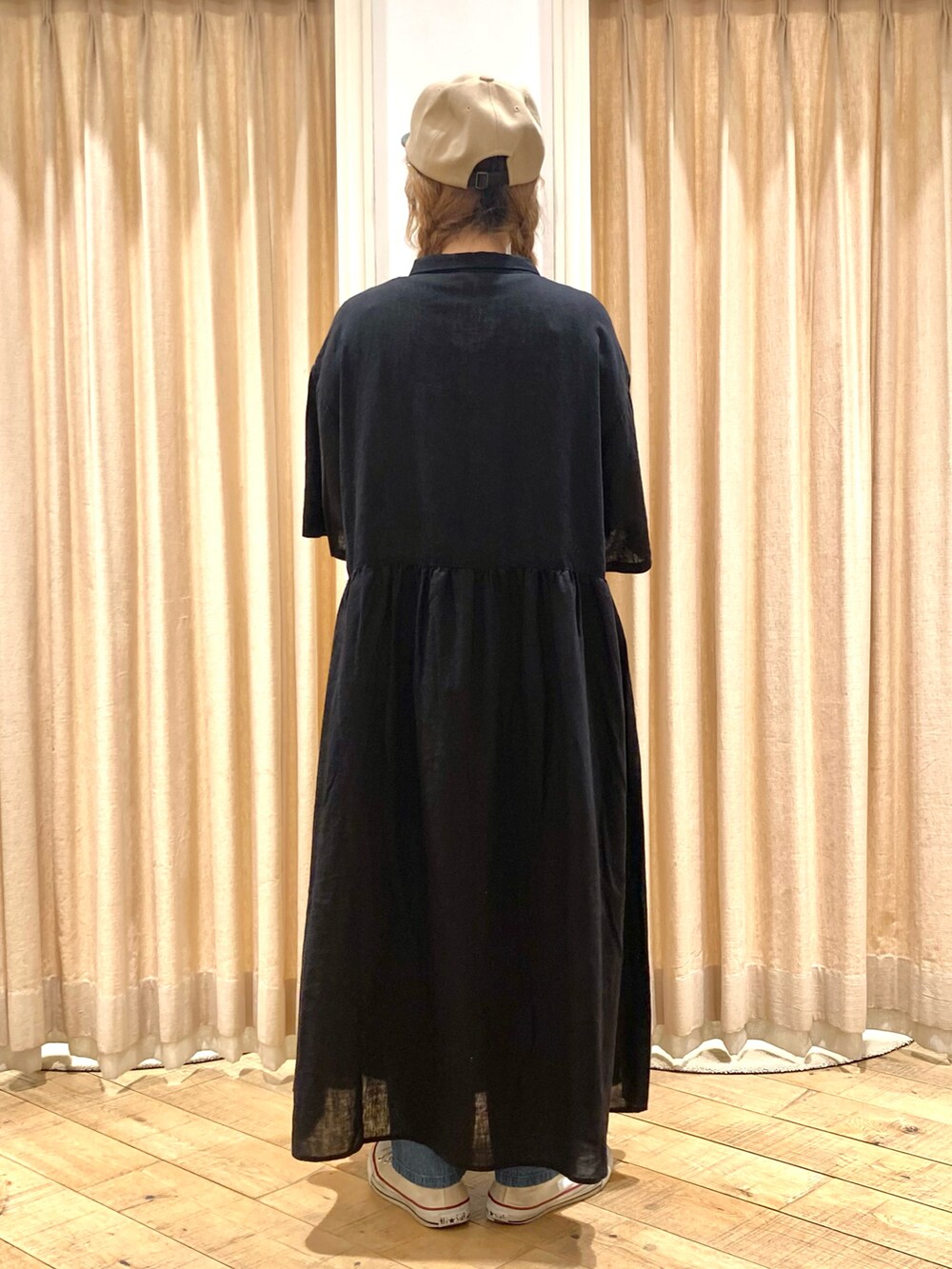 ブラック系のワンピース、ブルー系のデニムパンツ、ベージュ系のハンドバッグを着用したレディースの春コーディネートの3枚目の写真