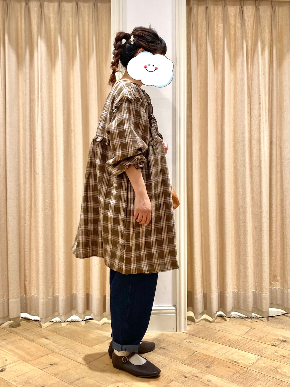 ブルー系のデニムパンツ、イエロー系のハンドバッグ、ブラック系のドレスシューズを着用したレディースの秋コーディネートの3枚目の写真