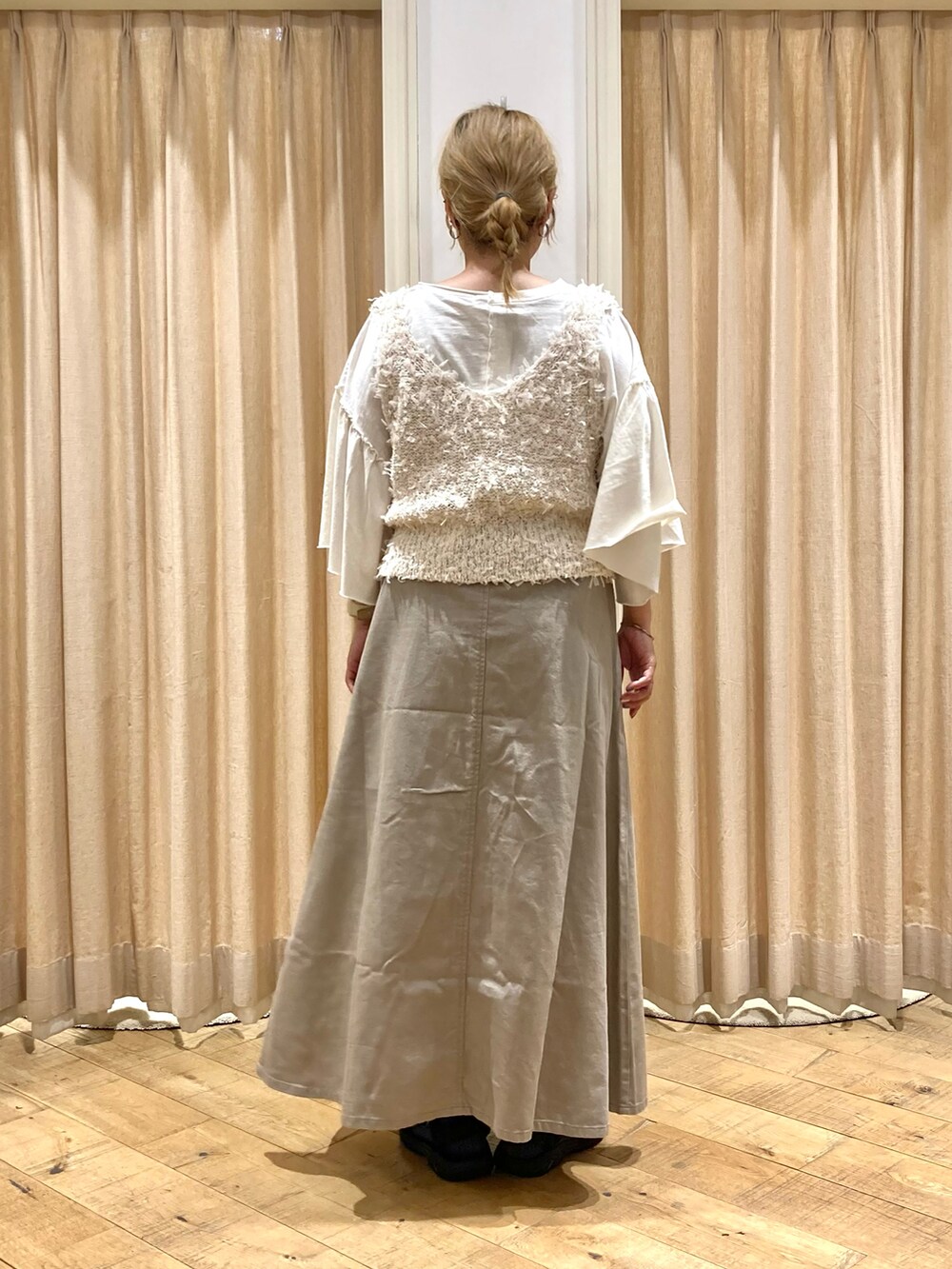 ホワイト系のTシャツ/カットソー、ホワイト系のベスト、ベージュ系のスカートを着用したレディースの秋コーディネートの3枚目の写真