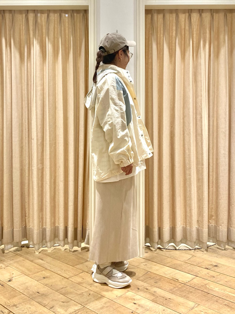 ホワイト系のブルゾン、グリーン系のTシャツ/カットソー、ベージュ系のスカートを着用したレディースの春コーディネートの4枚目の写真