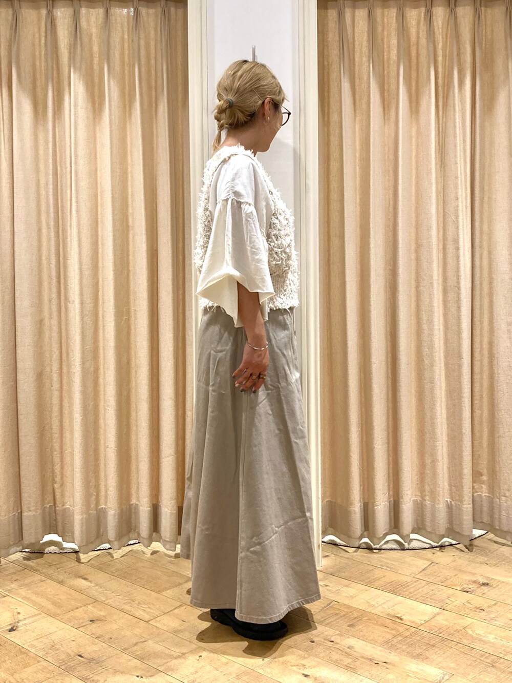 ホワイト系のTシャツ/カットソー、ホワイト系のベスト、ベージュ系のスカートを着用したレディースの秋コーディネートの4枚目の写真