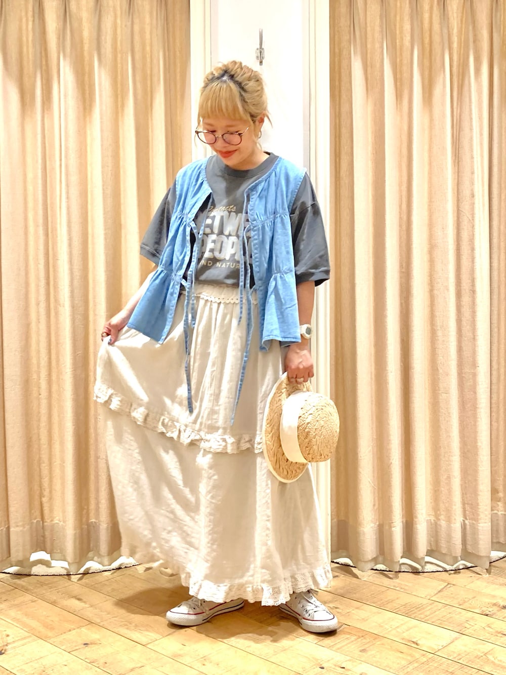 グレー系のTシャツ/カットソー、ブルー系のベスト、ベージュ系のスカートを着用したレディースの夏コーディネートの3枚目の写真