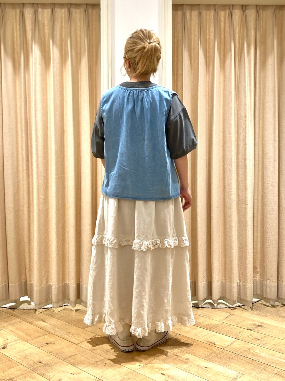 グレー系のTシャツ/カットソー、ブルー系のベスト、ベージュ系のスカートを着用したレディースの夏コーディネートの5枚目の写真
