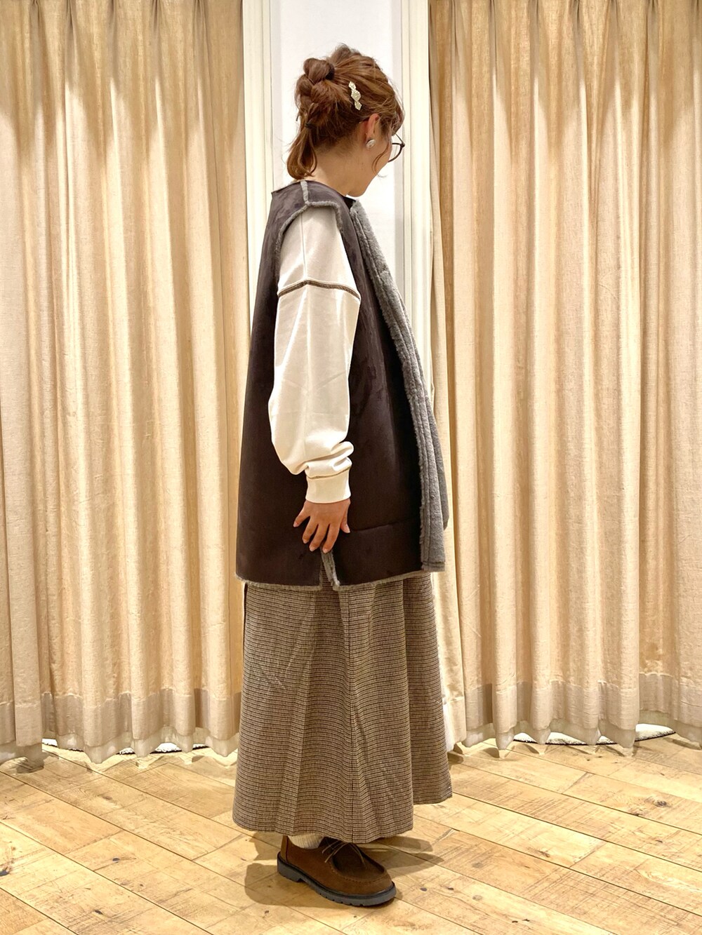 ホワイト系のTシャツ/カットソー、グレー系のベスト、ブラウン系のその他パンツを着用したレディースの秋コーディネートの5枚目の写真