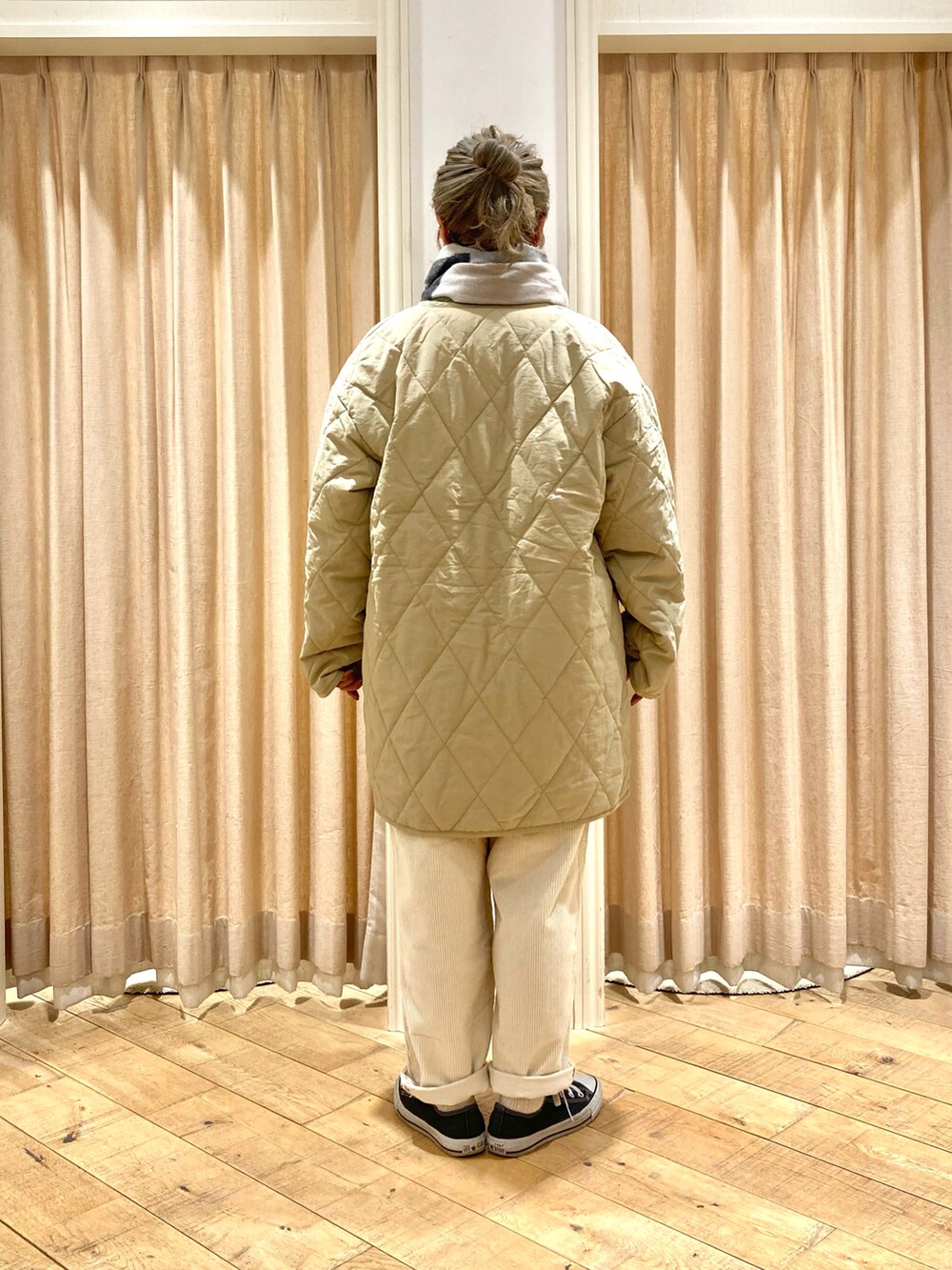 ベージュ系のその他アウター、グリーン系のニット/セーター、ホワイト系のその他パンツを着用したレディースの冬コーディネートの5枚目の写真