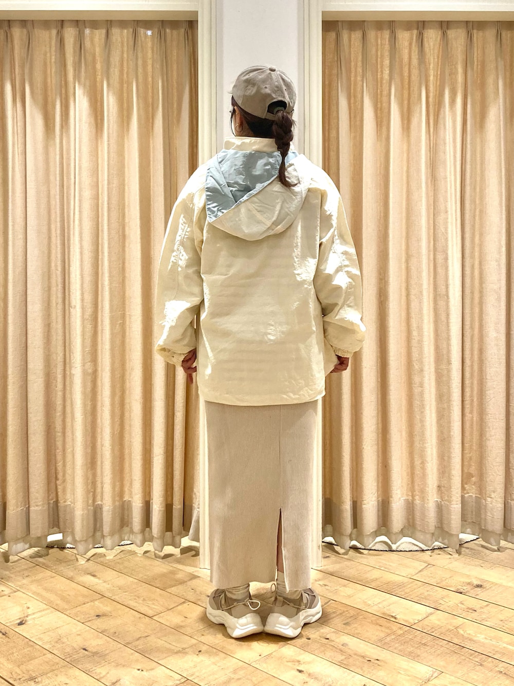 ホワイト系のブルゾン、グリーン系のTシャツ/カットソー、ベージュ系のスカートを着用したレディースの春コーディネートの3枚目の写真