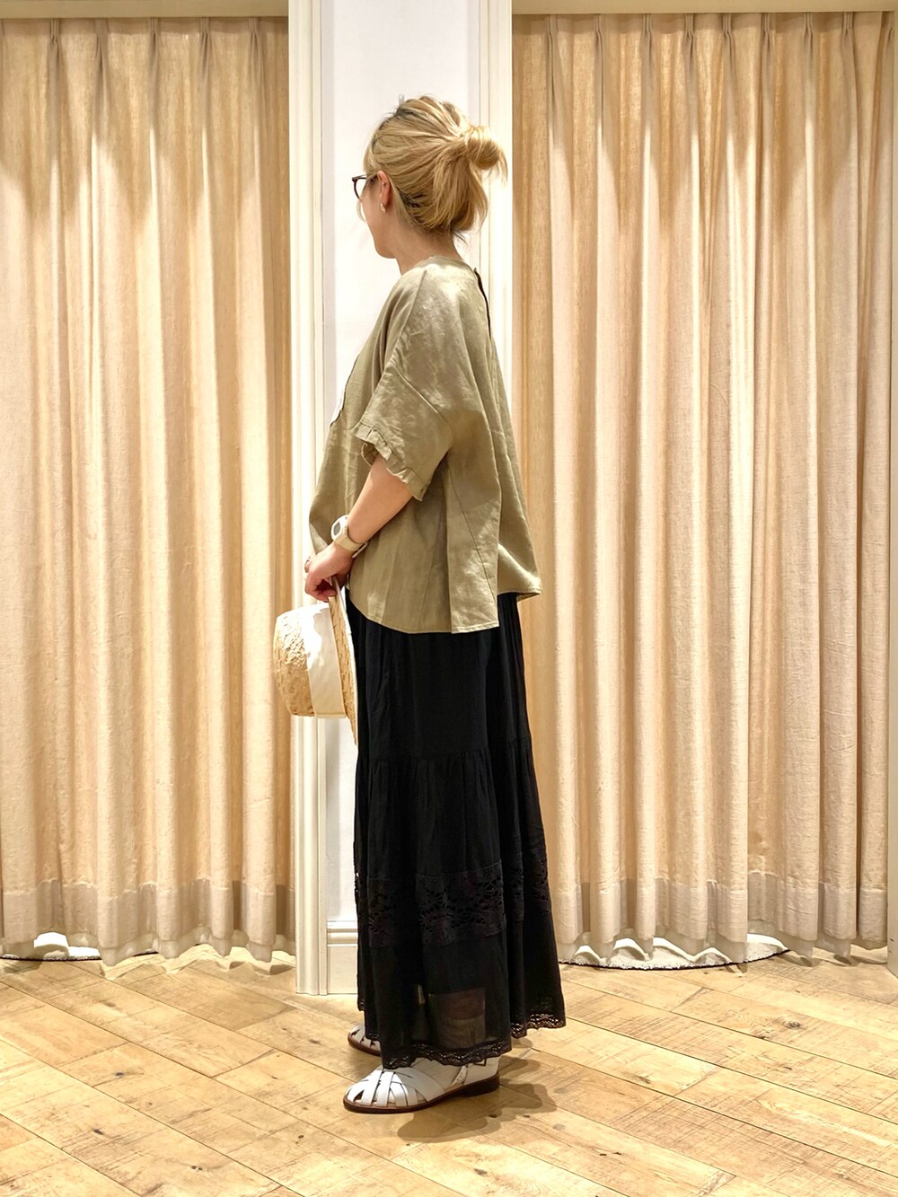 イエロー系のシャツ/ブラウス、ブラック系のスカート、ホワイト系のサンダルを着用したレディースの夏コーディネートの3枚目の写真
