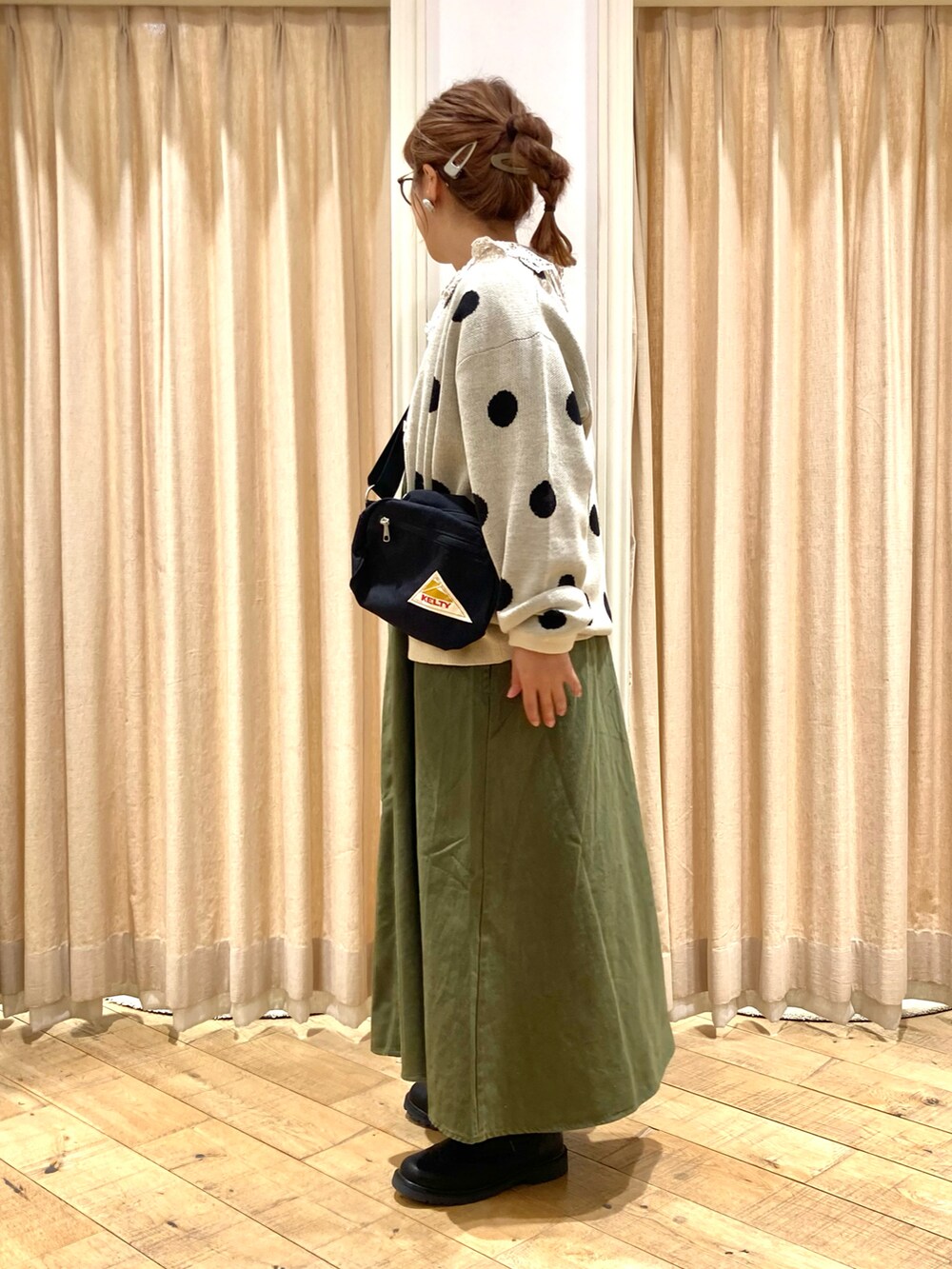 ホワイト系のカーディガン/ボレロ、ベージュ系のシャツ/ブラウス、グリーン系のワンピースを着用したレディースの秋コーディネートの3枚目の写真