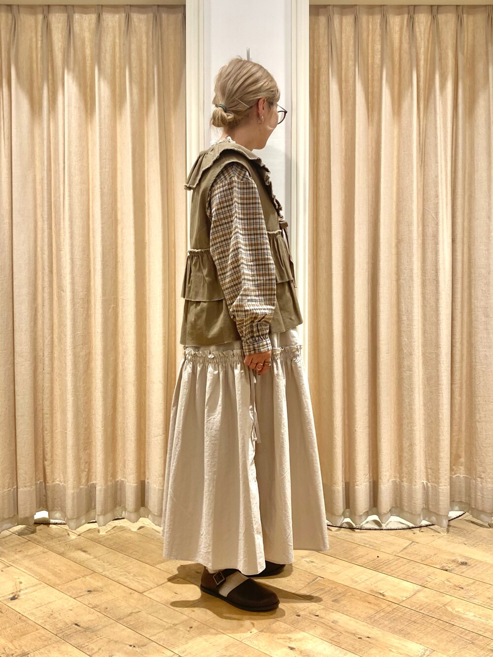 ホワイト系のシャツ/ブラウス、グリーン系のベスト、ベージュ系のスカートを着用したレディースの秋コーディネートの5枚目の写真