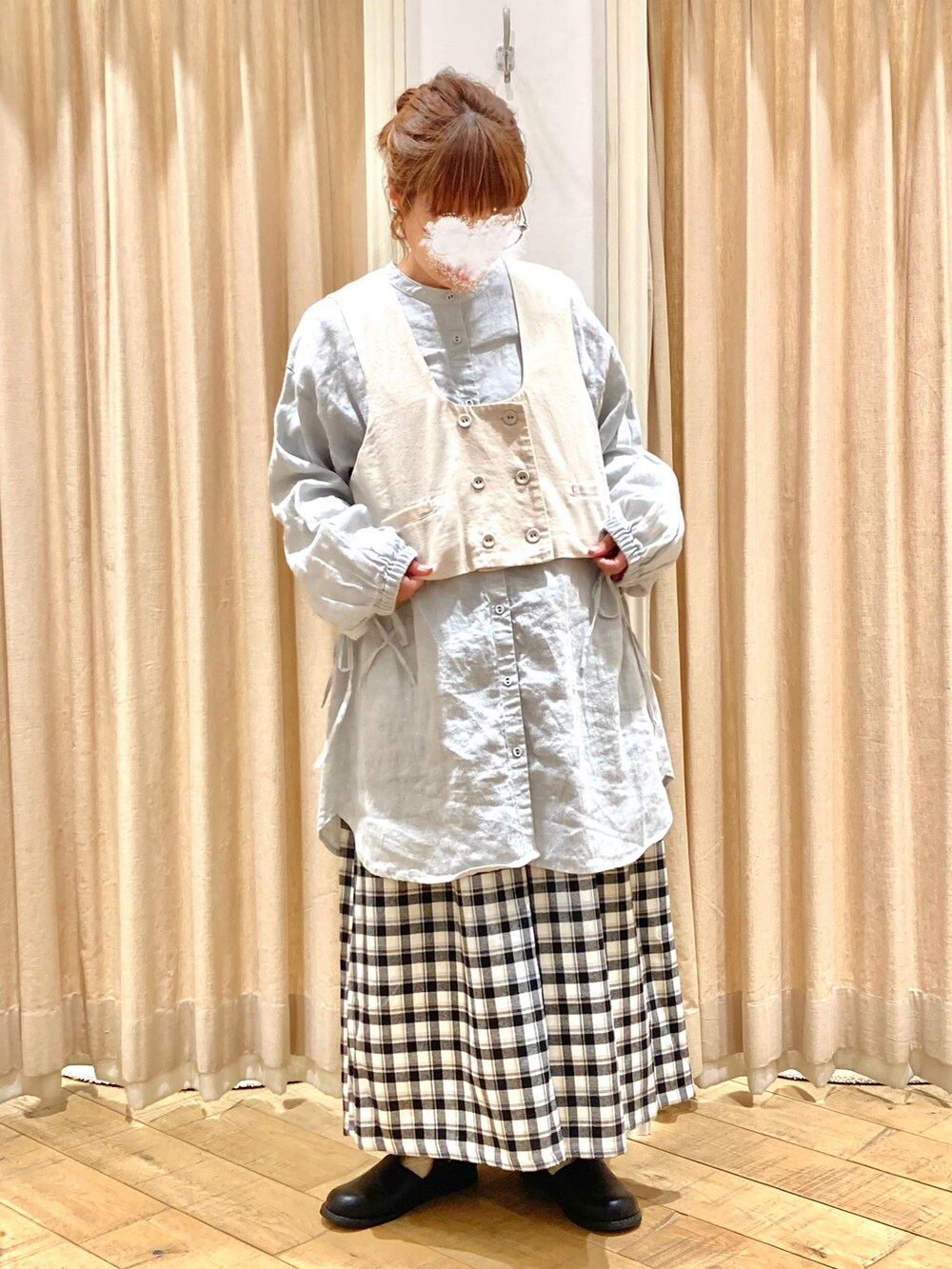 グリーン系のチュニック、ホワイト系のベスト、グレー系のその他パンツを着用したレディースの秋コーディネートの3枚目の写真