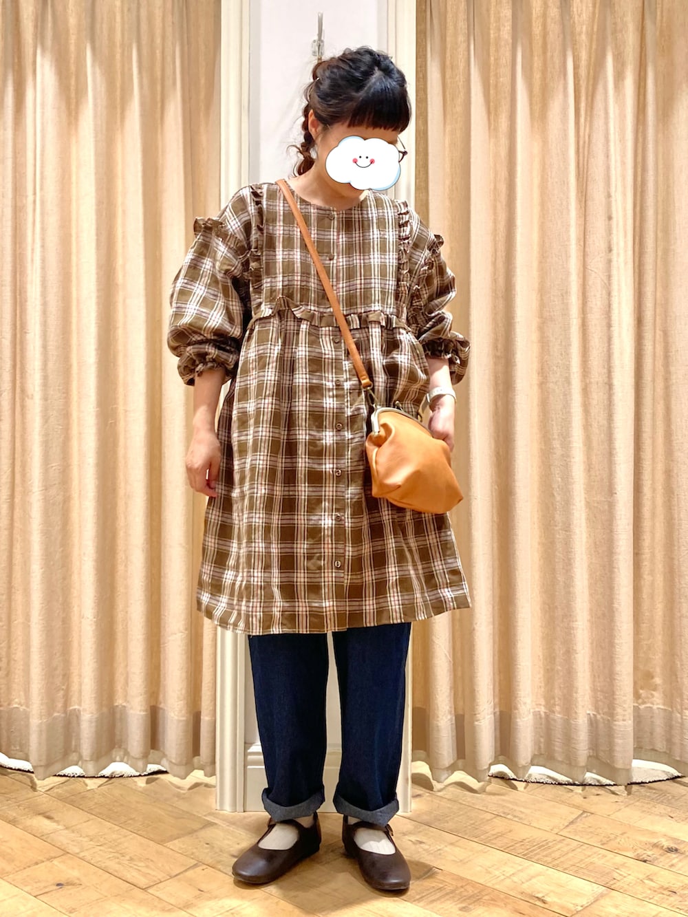 ブルー系のデニムパンツ、イエロー系のハンドバッグ、ブラック系のドレスシューズを着用したレディースの秋コーディネートの2枚目の写真